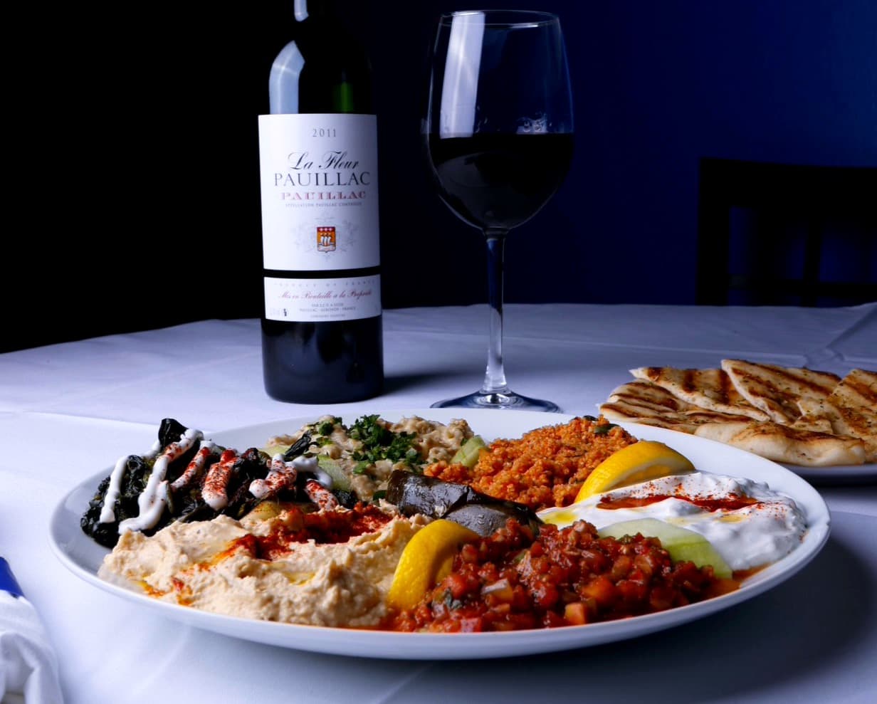 Mezze and grilled pita with wine, lit after dark